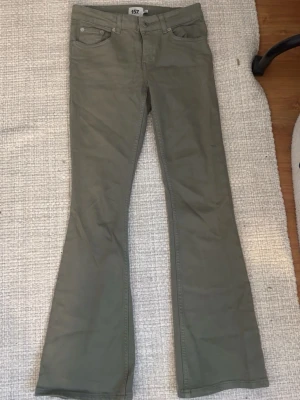 Bootcut byxor i khaki från 157, XS - Bootcut byxor från 157 i en snygg khakigrön färg. Modellen är low boot med låg midja och kort längd. Klassisk femficksdesign och tillverkade i mjuk bomull. Perfekta till sneakers eller boots för en chill look. Jag är 160 och de passar perfekt på mig🥰 endast provade!