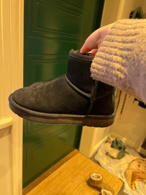 Svarta boots i mocka med foder - Mysiga svarta boots i mocka med mjukt foder på insidan. Skorna har rund tå, platt sula och är perfekta för kalla dagar. De är enkla att dra på och har en klassisk, stilren look som passar till det mesta.