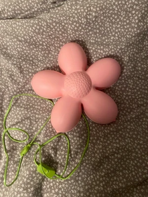 Blom lampa från IKEA - Blomformad vägglampa i rosa plast med grön sladd och strömbrytare.