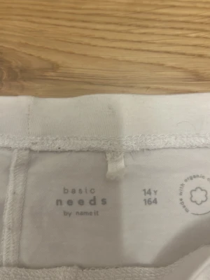 Vita basic shorts från Name It - Ett par enkla vita shorts från Name It i mjuk bomull. Modellen är rak och midja utan synliga detaljer, perfekt för chill dagar. Passar dig som gillar minimalistisk stil och vill ha något bekvämt till sommaren.