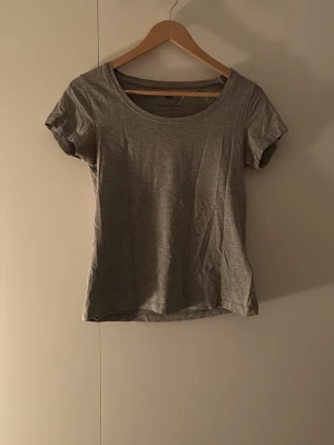 Grå basic t-shirt med rund hals - Enkel grå t-shirt från lager 157 med rundad halsringning och korta ärmar. Perfekt till jeans eller shorts och superlätt att matcha med andra plagg. Tillverkad i mjuk bomull för skön känsla hela dagen.