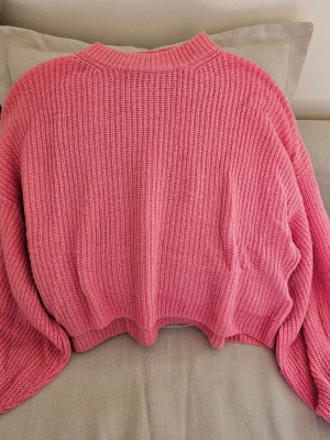 Rosa stickad tröja från Miss Selfridge - Superfin rosa stickad tröja från Miss Selfridge i en loose fit. Tröjan har ribbade muddar och är gjord i en mjuk blandning av akryl och ull. Perfekt för kyliga dagar och enkel att styla med jeans eller kjol. Kort, fluffig och Oversized 