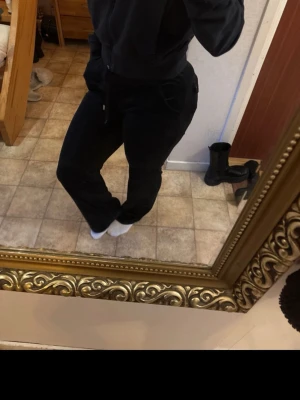 Svarta juicy couture byxor  - Säljer ett par svarta manchesterbyxor med hög midja och raka ben. Byxorna har snörning i midjan, fickor fram och bak med knappdetaljer. Perfekta för dig som gillar en chill och snygg look.