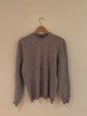 Grå merinoulltröja från Benetton - Klassisk grå tröja från United Colors of Benetton i merinoull. Ett mycket bra skick och väl omhändertagen. Priset kan självklart diskuteras! Nypris: ca 1200kr