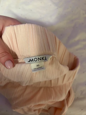 Ljusrosa ribbade byxor från Monki XS - Säljer ett par ljusrosa ribbade byxor från Monki i storlek XS. Byxorna har resår i midjan och är tillverkade i ett mjukt, stretchigt material som känns skönt mot huden. Perfekta för en chill och avslappnad stil.