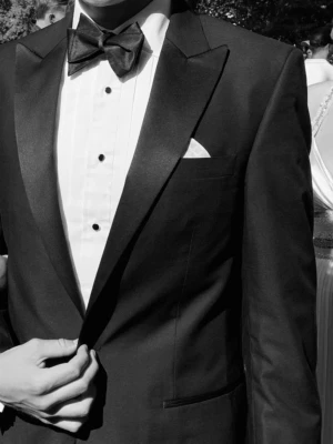 Klassisk svart smoking helt set - Säljer en klassisk svart smoking. Setet inkluderar kavaj med spetsiga slag, svarta byxor, vit skjorta med svarta knappar, lackskor och svart äkta fluga.  Passar någon som vanligtvis har L (180 - 190) Kavaj - 50, Byxor - 52, Skjorta - M, Skor - 52. Passformen är rak som en klassisk smoking, perfekt för bal eller nyår. Nypris för allt är cirka 6000