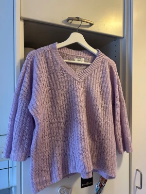 Ljuslila stickad tröja från ONLY - Mysig ljuslila stickad tröja från ONLY med v-ringning, korta ärmar och en avslappnad, bekväm passform