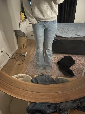 Ljusblå bootcut jeans - Säljer ett par ljusblå jeans med bootcut passform. Klassisk femficksmodell med normal midja och lätt utsvängda ben. Jeansen är i mjukt denimtyg och har en snygg tvättad look. Perfekta till sneakers eller boots.