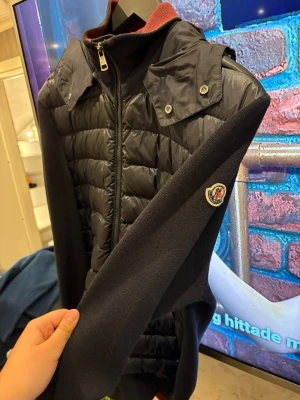 Svart dunväst från Moncler - Säljer en svart dunväst från Moncler men den är INTE äkta. En liten skavank men syns på bild! 
