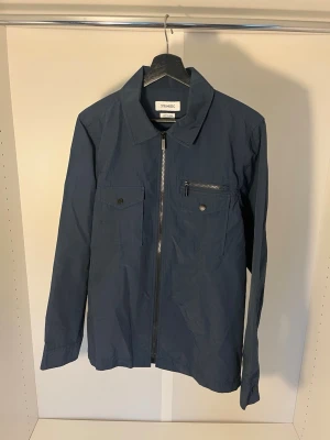 Mörkblå overshirt från Strömberg - Snygg mörkblå overshirt från Strömberg med bröstfickor med knappar och en bröstficka med dragkedja.  Strl S. Pris går att diskutera 