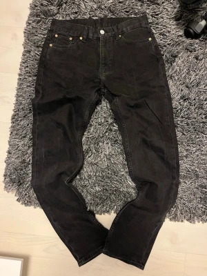 Svarta Weekday Easy jeans 27/32 - Säljer ett par svarta Weekday Easy jeans i storlek 27/32. De har klassisk femficksdesign, raka ben och normal passform. Jeansen är tillverkade i bomull och har en enkel, stilren look som passar till det mesta.