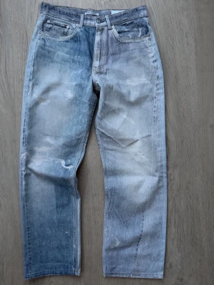 Our legacy third cut  - Säljer ett par ljusblå raka jeans från our legacy med slitna detaljer och tvättad look. Jeansen har fem fickor, knappgylf och klassisk passform. Perfekta för en avslappnad och trendig stil.