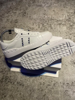 Valentino Rockstud skor - Ett par riktigt schyssta Rockstuds, vita med silvriga spikar och i storlek 42 EU. Skorna är i mycket fint skick och låda med mera medföljer självklart i köpet👍. Hör gärna av er vid frågor om vad som helst så löser vi något😁.