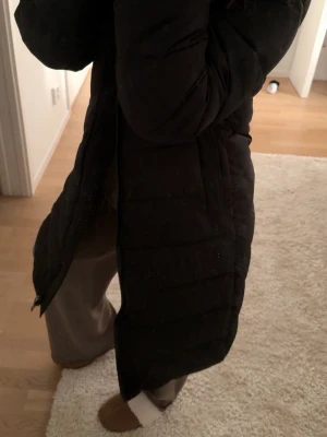 Mango vinterjacka  - Säljer en svart lång dunjacka från mango ’BEGO’ modellen i XS. Jackan har en rak passform och håller värmen under kalla dagar. Perfekt för vintern och riktigt skön att bära. Helt ny.
