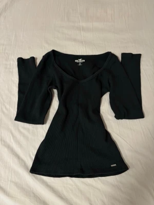 Hollister topp - säljer en snygg vintage topp från Hollister med o-ringad hals och lång ärm. Modellen är figurnära och stretchig och är i bra skick! 