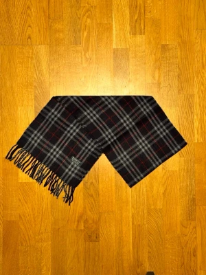 Mörkblå Burberry halsduk - Säljer en mörkblå halsduk från Burberry. Halsduken är i bra skick och är gjord i 100% lamull. Var inte rädd för några frågor. Pris diskuteras inte!