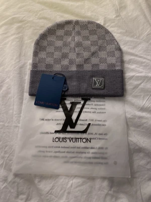 Grå mössa - Snygg grå mössa med klassiskt rutmönster och logga framtill. Kan va lite tajt i början men töjer sig