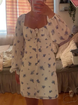 Vit blommig kortklänning - Vit kortklänning med blått blommönster från Gina tricot. 