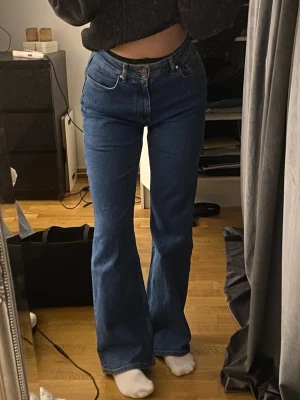 Blå bootcut jeans från Unoe Denim - Säljer ett par blå bootcut jeans från Unoe Denim Jeansen har en snygg utsvängd passform och är gjorda i ett mjukt denimtyg. 