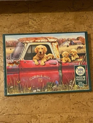 Cobble Hill pussel med söta hundvalpar🥰 - Pussel med över 1000 bitar från Cobble Hill. Motiv med fyra söta hundvalpar i en rostig röd pickup på landet, med gård och höstfärger i bakgrunden. Perfekt för dig som gillar djur och utmanande pussel! Endast använd 1 gång!💕