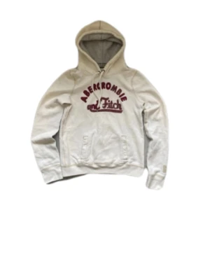 Vit hoodie från Abercrombie & Fitch - Snygg vit hoodie från Abercrombie & Fitch med broderad röd logga på bröstet. Trendig just nu o svårt att få tag i denna. Mjuk bomullsblandning som är skön att ha på sig. Hör av dig vid fler frågor!