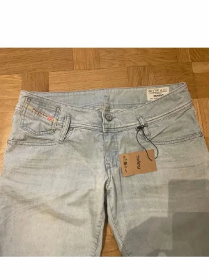 Diesel jeans - Snygga ljusblå jeans från diesel med klassisk femficksdesign och låg midja. Jeansen har en diskret tvättad look och detaljer som diesel-logga på myntfickan. Perfekta för en avslappnad och trendig stil.