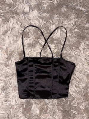 H&M topp  - Säljer en svart snygg topp från h&m med snörning i ryggen, strl xs. Fint skick.