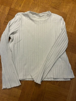 Vit ribbstickad tröja Kappahl XS - vit stickad tröja från Kappahl i storlek XS. Tröjan har ribbstickat mönster, rund halsringning och långa ärmar. 