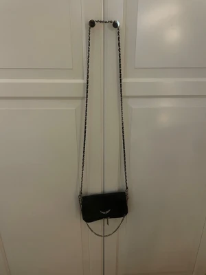 Zadig volataire väska - Jag säljer mina Zadig Voltaire väska i modellen Rock Clutch. Den är sparsamt använd och har defekter som små missfärgningar på kedjan. Den lilla kedjan är också av på ena sidan men där har jag satt en ring (se bild 4) men inget som syns när den används.