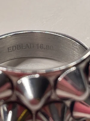 Silvrig ring med nitar från Edblad - Säljer denna populära ring i silver från Edblad! Den är andvänd typ 2 gånger och är som ny. Har tyvärr tappat bort kartongen så den kommer med en påse. Orginal pris 399