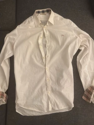 Burberry skjorta  - En burberry skjorta i stolek s den är i bra skick därmed det låga priset.                             Skriv vid några funderingar 