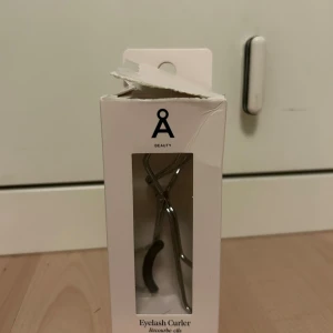 Ögonfransböjare - Säljer en helt ny ögonfransböjare från Åhléns. Aldrig använd endast öppnad, därför den inte går att lämna tillbaka. Kommer med en extra svart gelé grej.
