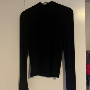 Svart polotröja  - Svart polotröja från Gina Tricot i storlek S. Tröjan har lång ärm och en klassisk polokrage som ger en clean och stilren look. Materialet är mjukt och stretchigt. Enkel att matcha med jeans eller kjol. Säljer pga att den inte kommer till användning längre 💗