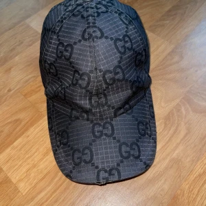 Svart Gucci keps med GG-mönster - Har använt den några månader fast den är jätte bra kondition och är äkta. Den enda anledningen jag säljer den så billigt är att jag vill bli av med den