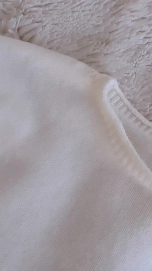 Vit stickad tröja med ribbade detaljer - Säljer en stilren vit stickad tröja med rund hals och långa ärmar. Köptes i en fin butik i Thailand och är helt oanvänd🤍
