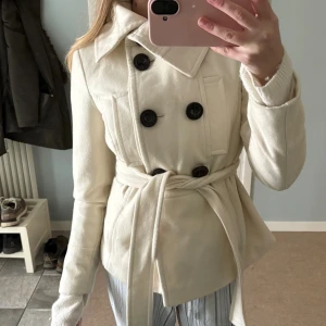 Zara kappa - Säljer denna korta kappan från Zara, det finns snörning och knappar på den och den är i superfint skick och tjockt material! Endast nvänd fåtal gånger, det står storlek M men den passar mer XS-S 🤗 använd gärna köp nu funktionen 💸
