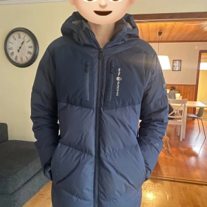 Mörkblå dunjacka från Sail Racing - Modellen är 183 cm lång, passar bra och är varm 