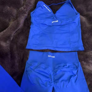 DFYNE sett blå träningsett - säljer mitt fina blåa DFYNE sett💙 storlek M (men passar även mig som brukar ha S), inga defekter, kan skicka med påse som de kom i, nyskick, färgen deep sea! kom gärna med rimliga prisförslag💞😀