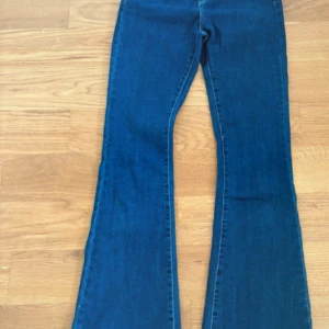 Blå bootcut jeans XS från Cubus - Snygga blå jeans från Cubus i storlek XS med klassisk bootcut passform. Jeansen har en mörkblå ton, raka ben som blir vidare nedtill och är tillverkade i mjukt denim-material. Perfekta för dig som gillar retrovibbar och vill ha ett stilrent plagg i garderoben.
