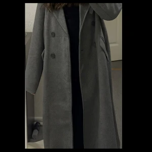 Grå kappa - Grå lång kappa från bubbleroom. Endast använd en gång. Nyskick. Hör av dig om du vill se fler bilder!