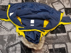 Blå och gul parkajacka med päls - Säljer en blå och gul parkajacka från Didriksons med huva och fuskpäls. Jackan har dragkedja, två fickor med dragkedja och reflekterande detaljer på ryggen. Insidan är fodrad och jackan har en loose passform, perfekt för kalla dagar.Den går bra för barn. 