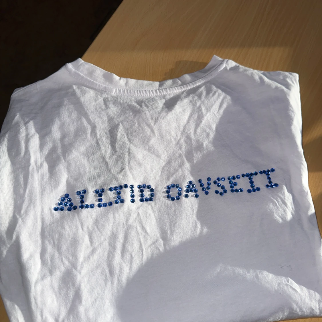 Vit t-shirt med blå paljetter på ryggen  - 1