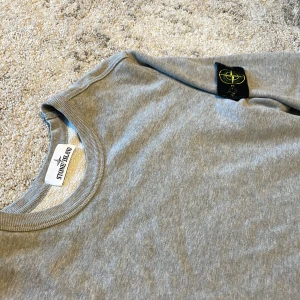 Grå Stone Island sweatshirt - Stones Island tröja i fint skicka såklart äkta. Säljer pga passar mig inte längre strl L