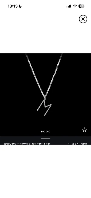 Maria Nilsdotter halsband  - Stilrent halsband i silver med en cool, sned bokstav M som hänge. Kedjan är tunn och klassisk, perfekt för dig som vill ha något personligt och unikt. Passar dig som gillar minimalistisk design med en twist. Längd 45