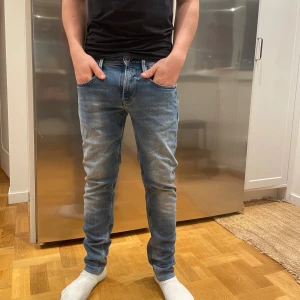 Replay ljusblå jeans slim fit - Säljer ett par snygga Replay anbass jeans i ljusblå tvätt med klassisk femficksdesign och Replay-logga på fickan. Jeansen har slim passform, normal midja och är tillverkade i mjukt jeanstyg. Perfekt för dig som gillar stilrena och moderna jeans. PS modellen på bilden är 173cm lång. Slå bara en pling 🛎️ kring några funderingar.