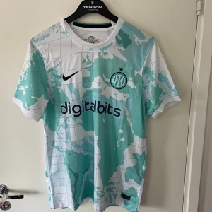 Inter Milan fotbollströja - Säljer en Inter Milan fotbollströja från Nike med unikt världskarta-mönster i turkos och vitt. Tröjan är riktigt fet till sommaren eller när som 