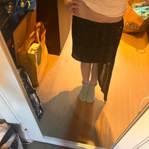 Svart glitter kjol (BIK BOK) - Jag säljer denna jättefina svarta glitter kjolen med en supper snygg tyg detalj på sidan från bikbok i storleken S. Den är bara använd en gång. 