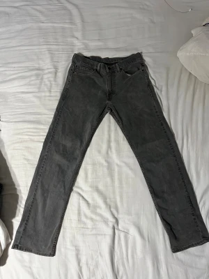 Grå Levi's 505 jeans straight fit - W33 L32 Säljer ett par grå Levi's 505 jeans med klassisk straight fit och fem fickor. Jeansen har gul kontrastsöm, Levi's patch bak och röd Levi's-tag vid bakfickan. Materialet är denim och modellen har normal passform.