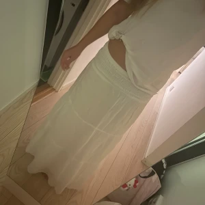 Vit långkjol med smock i midjan 🫰🏼 - Säljer en vit långkjol med smockad midja och lätt, flowigt tyg. Den är jätte bekväm och fin ❤️