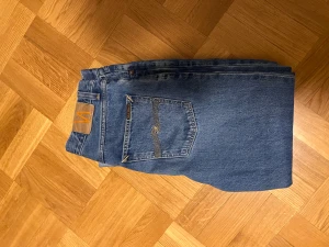 Nudie jeans | Hazy Hank - Säljer ett par feta blå jeans från Nudie Jeans (Hazy Hank) med snygga kontrasttrömmar i storlek 34:32